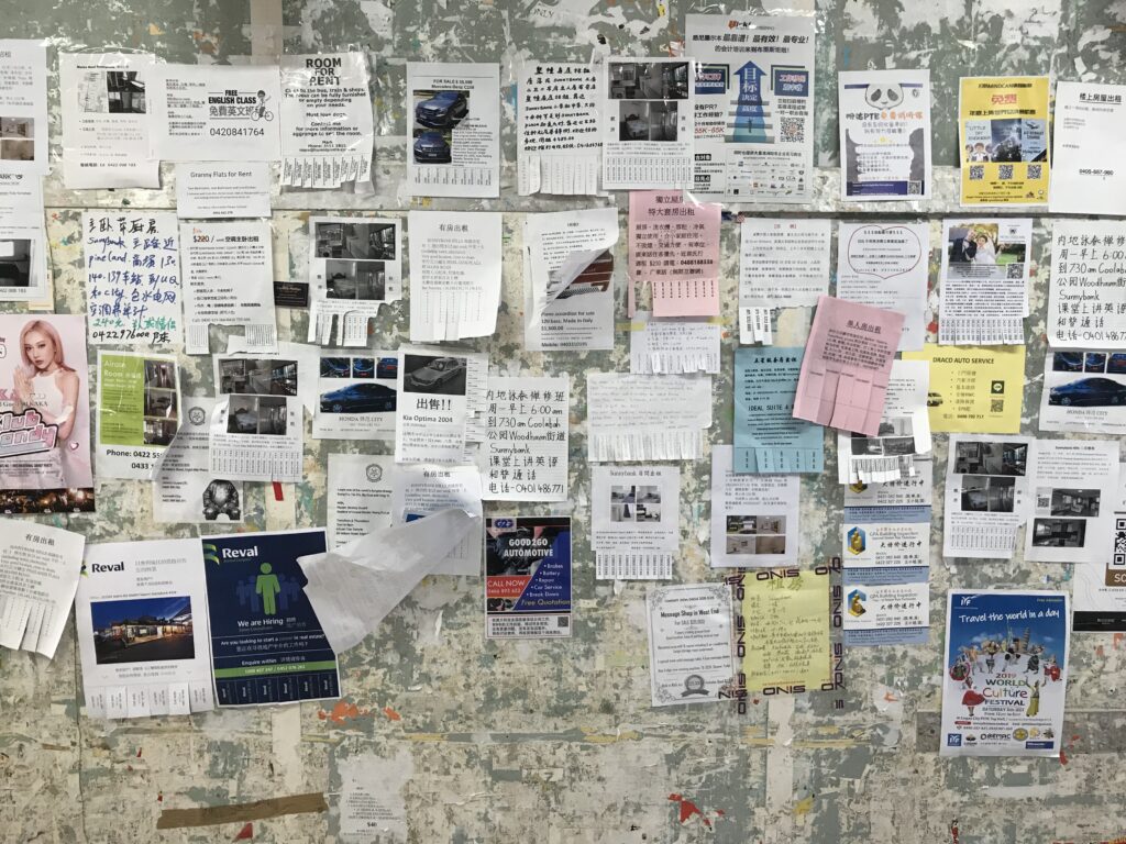 Sunnybank墙特写，传单重叠，撕下电话号码的纸条，旧胶带痕迹