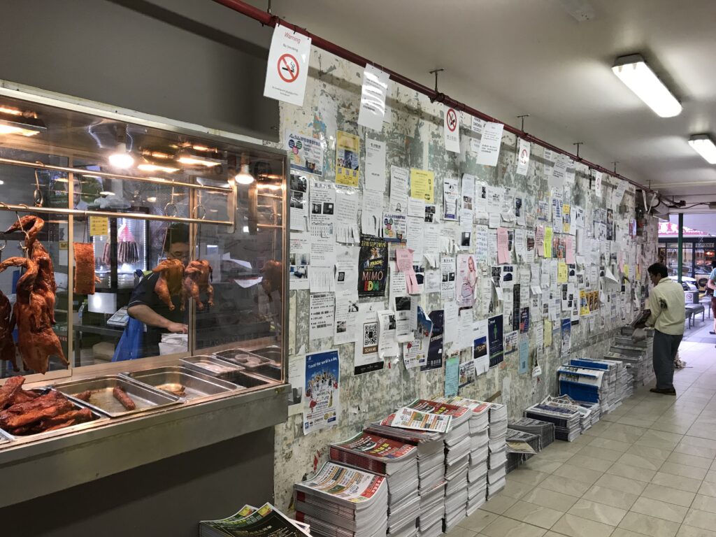 Sunnybank墙从烧腊窗一端拍向另一端，传单覆墙，报纸沿墙根堆叠