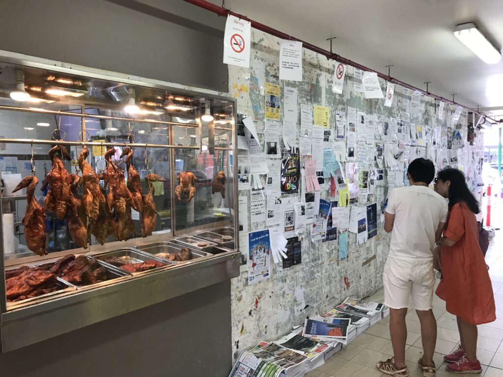 Sunnybank墙烧腊窗旁，墙面满贴传单，一人驻足阅读