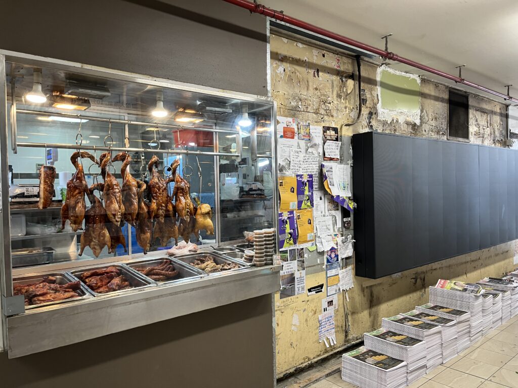 Sunnybank墙烧腊窗端，LED屏关闭，裸露砖墙，传单报纸堆叠