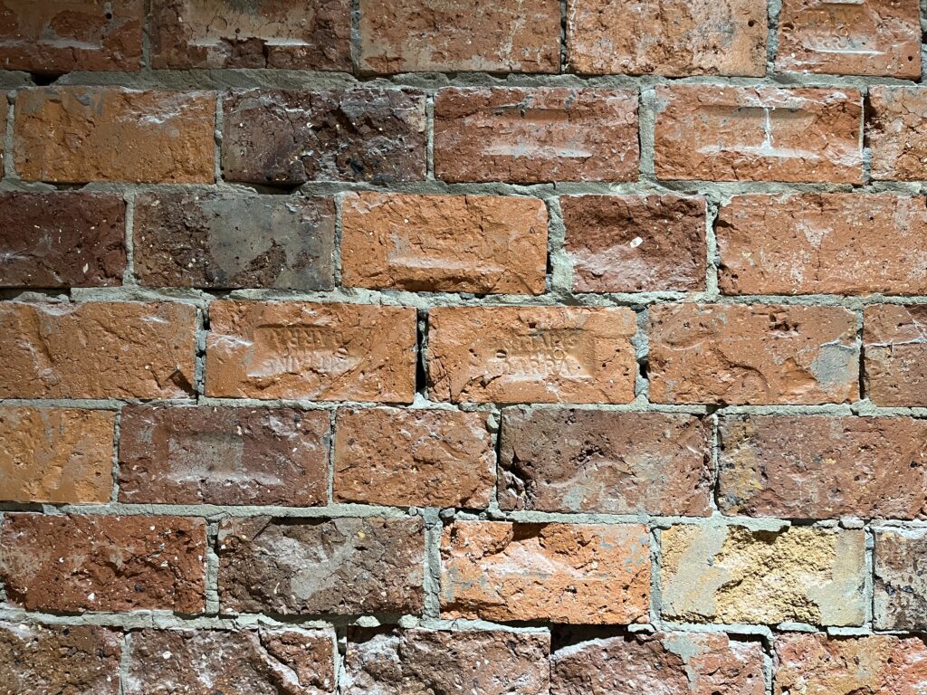 粗面粘土砖墙，红褐色砖块紧密排列，深灰色砂浆
