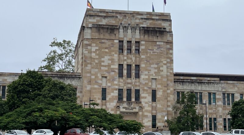 昆士兰大学福根史密斯楼砂岩建筑，1930年代历史地标，国旗飘扬，阴天宁静校园氛围，打卡点