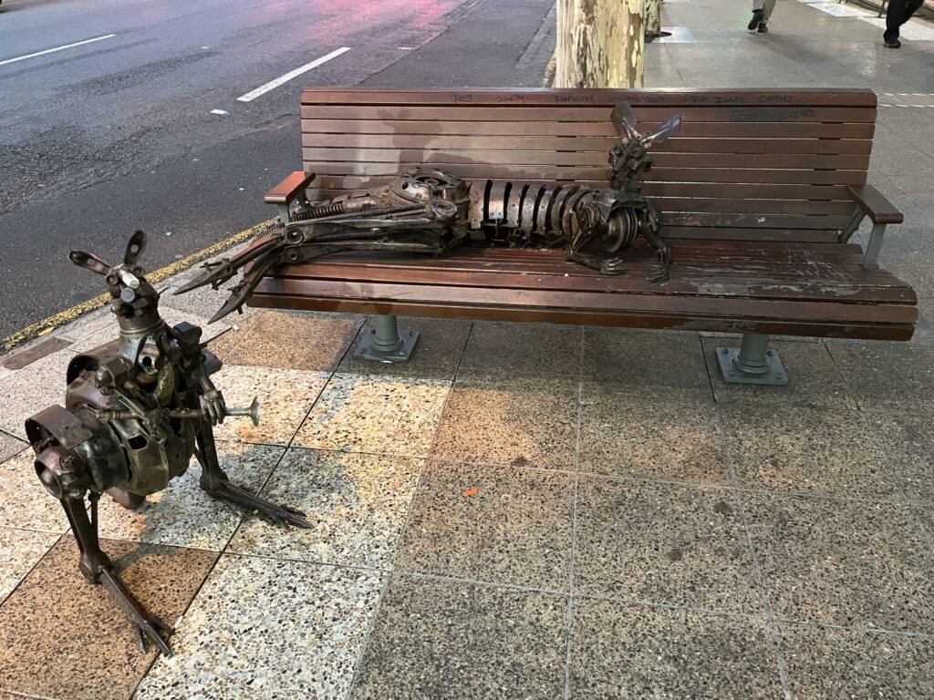 布里斯班乔治街公交长椅，一只金属袋鼠躺卧，另一只站立凝视，街头艺术品