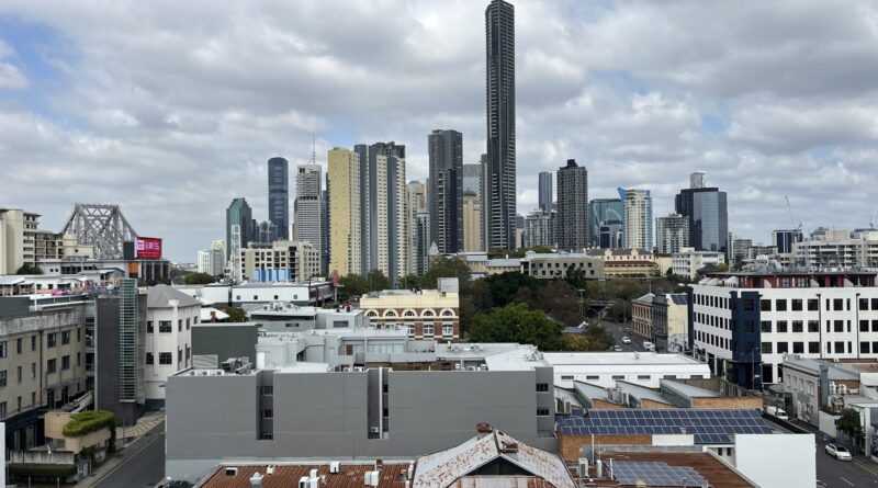 布里斯班CBD城市景观，远处故事桥桥塔，前景内城屋顶，蓝天白云