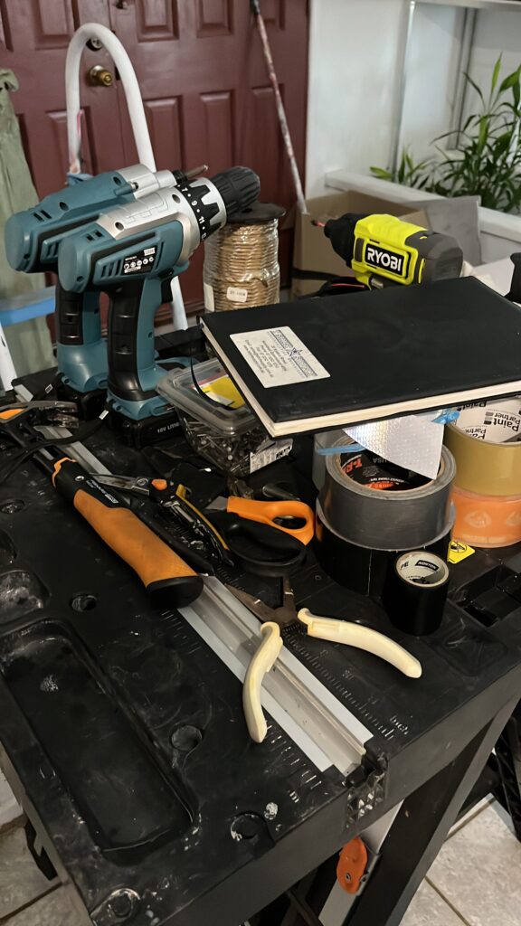 夜晚工作台摆满工具，锤子钉子胶带绳索，备用梯子