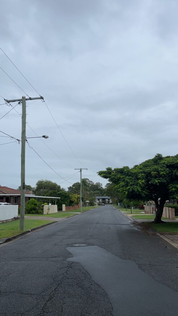气旋过后 suburban 街道，灰色阴天，空无一人，电线杆，远处房屋
