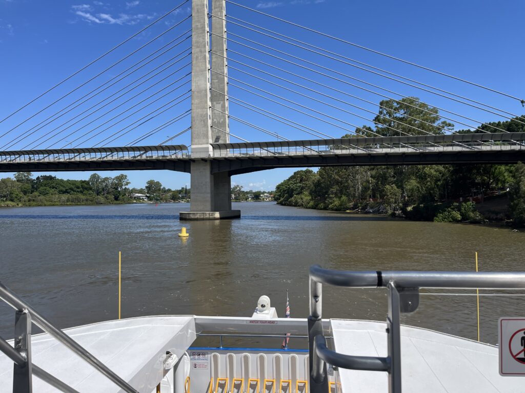 渡轮后排甲板回望绿桥，桥墩居中，河面蓝天