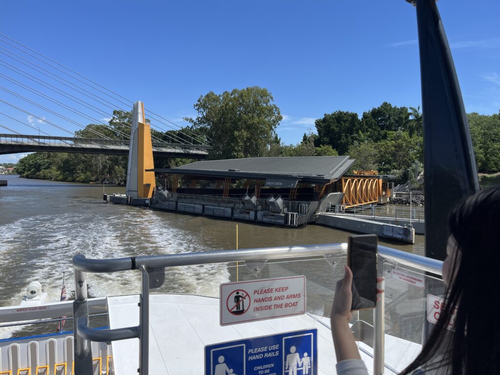 渡轮顶层回望，绿桥远景，白裙女孩举手机拍照