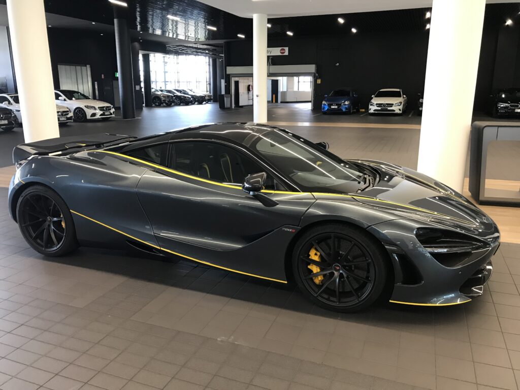 布里斯班展厅外，深灰色迈凯伦720S，黄色赛车条纹，黄色刹车卡钳，侧上视角