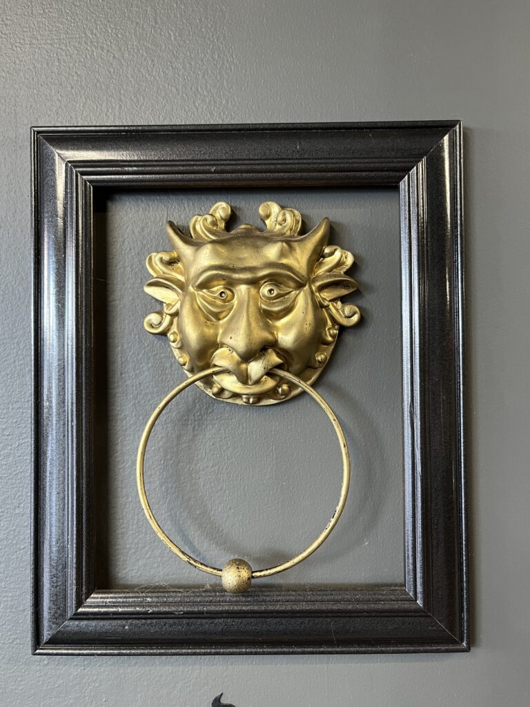 灰色墙面，黑色木框玻璃，金色石像鬼嘴含门环