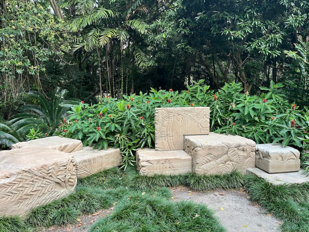 库萨山植物园花园角落，两堆方形砂岩块，随机排列，叶雕图案，草地灌木，打卡点