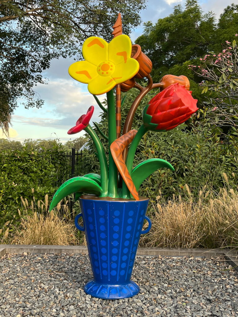 库萨山植物园大型蓝色花瓶雕塑，插满鲜花、野花、豆荚，花茎间夹着回旋镖，打卡点