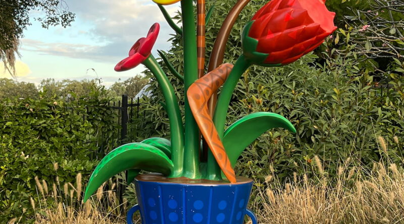 库萨山植物园大型蓝色花瓶雕塑，插满鲜花、野花、豆荚，花茎间夹着回旋镖，打卡点